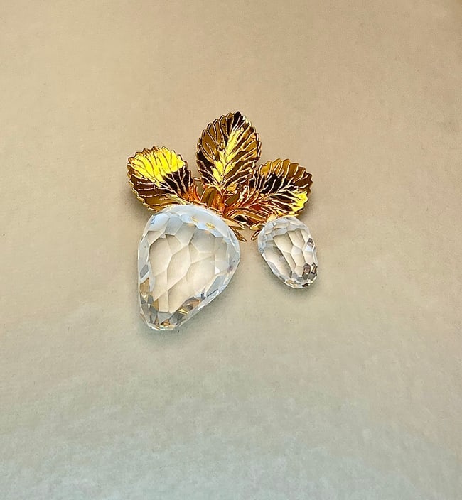 Swarovski Gold-Tone Strawberry Brooch with Faceted Crystal Fruit: A dazzling signed Swarovski brooch featuring two faceted clear crystal strawberries suspended from a trio of rich, gold-tone leaves. The strawberries sparkle with precision-cut brilliance, while the l