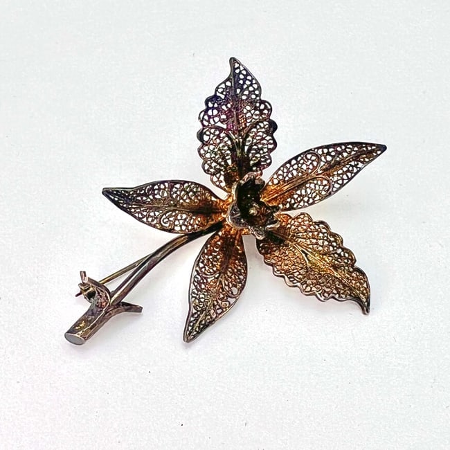 Vintage Vermeil Orchid Brooch: A finely crafted vintage brooch in the form of a blooming orchid, showcasing intricate filigree wirework and sculpted detail. While unmarked, the piece is non-magnetic and consistent in workmanship an