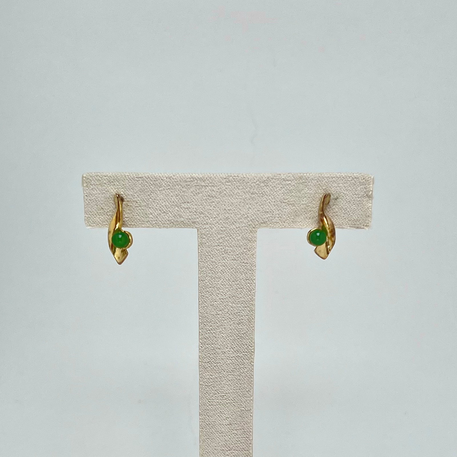 Vintage Gold Vermeil Sterling Silver Earrings with Nephrite Jade Cabochons: A charming pair of vintage post earrings crafted in sterling silver with a warm gold vermeil finish, styled in a sculptural leaf-like modernist design. Each earring is set with a round cabochon of nat