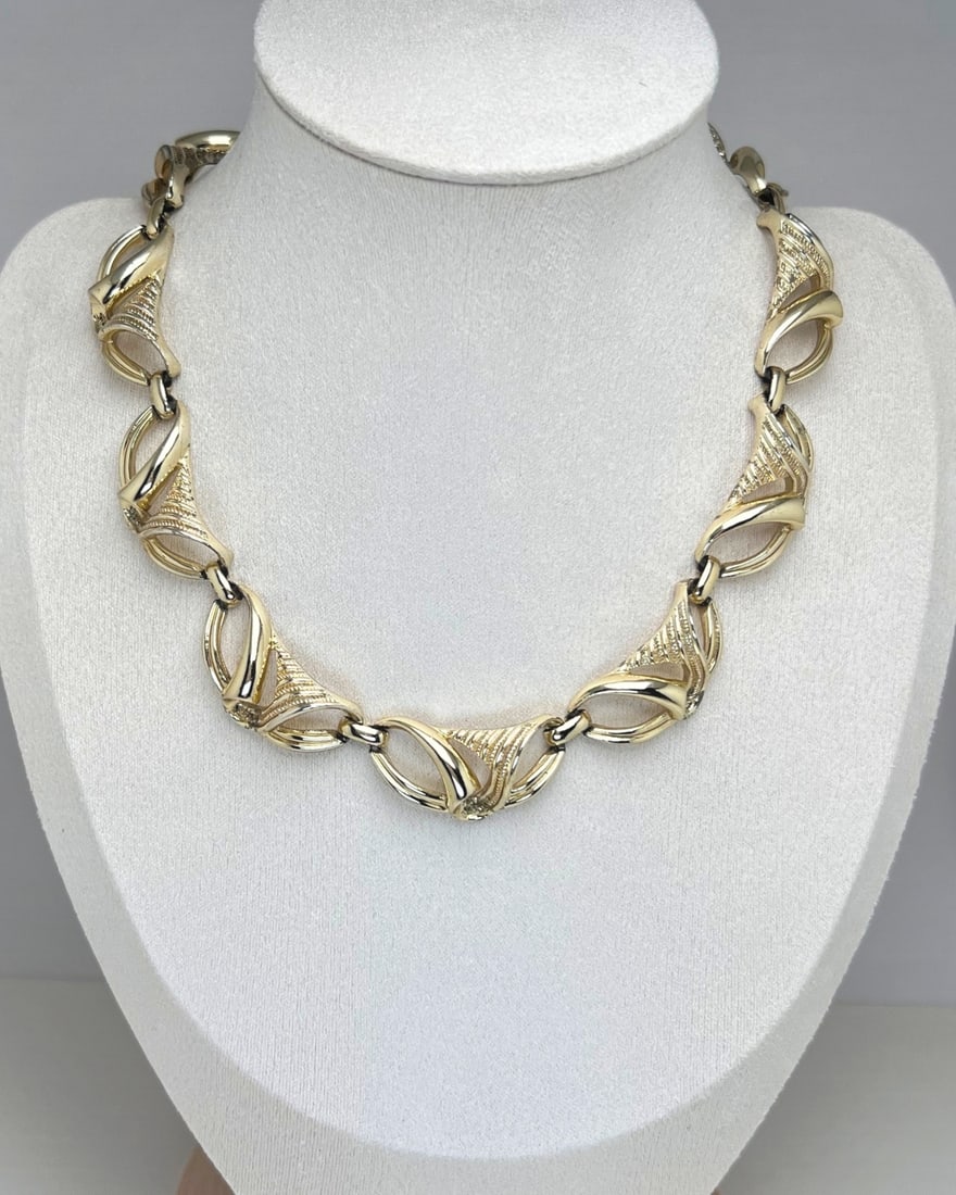 Vintage Coro Gold-Tone Sculpted Link Necklace: A striking vintage necklace by Coro, featuring sculptural gold-tone links with a dynamic openwork design reminiscent of folded ribbons or mid-century abstract motifs. Each link is intricately textured