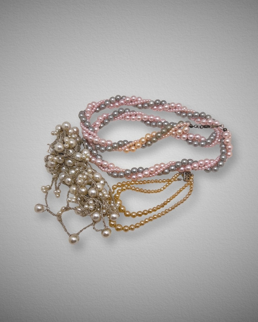 Vintage Faux Pearl Necklace Lot – Multi-Strand & Draped Styles: Charming vintage lot featuring several faux pearl necklaces in soft tones of cream, pink, gray, and gold. Includes:•A twisted multi-strand necklace with alternating pink and gray faux pearls&bull