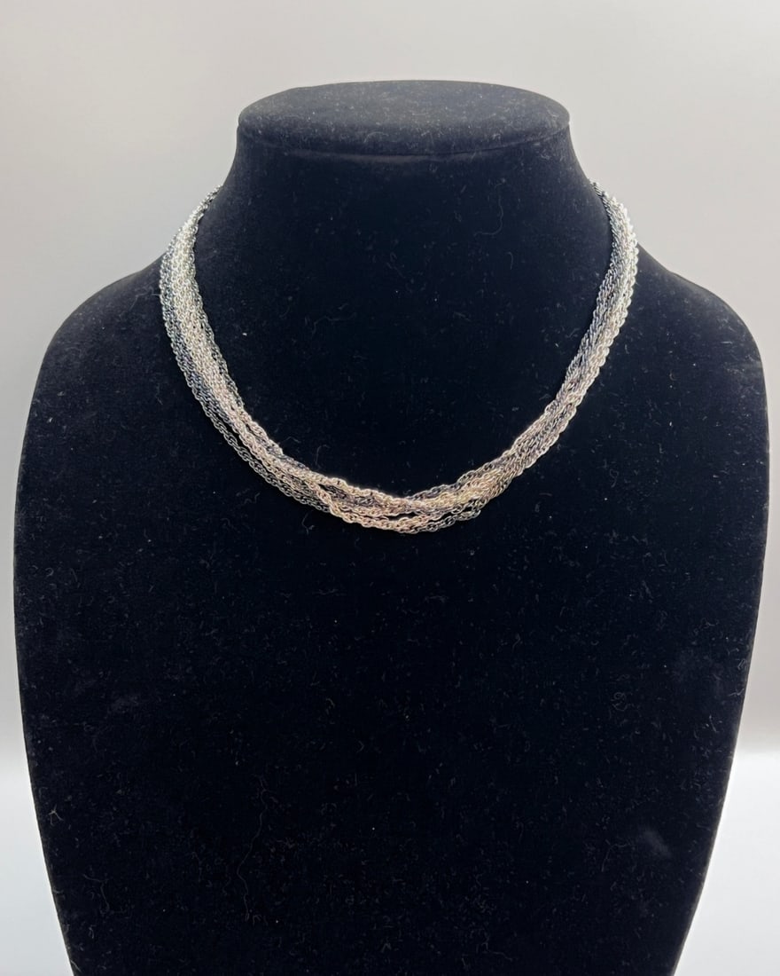 Vintage Trifari Multi-Strand Twisted Chain Necklace with Oxidized Silver Tones: A striking vintage Trifari necklace featuring multiple strands of fine chain in a twisted rope design. The chains blend polished and oxidized silver tones for a dynamic, dimensional look. Centered wit