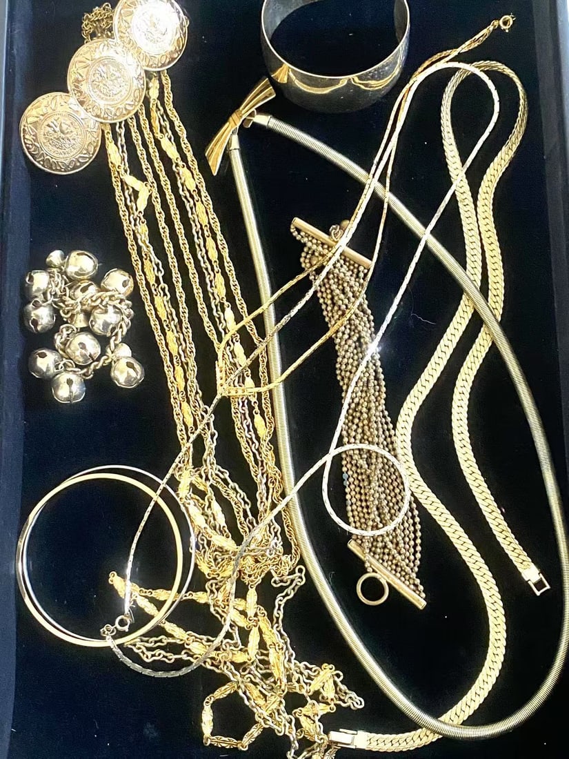 Gold-Tone Vintage Mixed Jewelry Lot: This lot includes a variety of gold-tone jewelry pieces, such as embossed coin fringe necklaces, wide cuff bracelets, snake chains, flat curb chains, chunky bead bracelets, thin bangles, and beaded ta