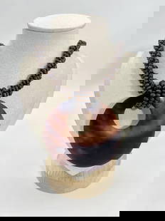 Braided Coconut Bead Necklace with Large Circular Pendant: This striking necklace features tightly braided dark coconut shell beads and a large circular pendant with a natural marbled gradient finish. The organic tones and tactile textures lend an earthy, tro