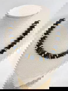 Tribal Style Dark-Toned Disc Beaded Necklace: Composed of flat disc-shaped beads in dark brown, cream, and navy tones, this necklace embodies a rustic, tribal-inspired aesthetic. The materials resemble wood, coconut shell, or resin, offering a na