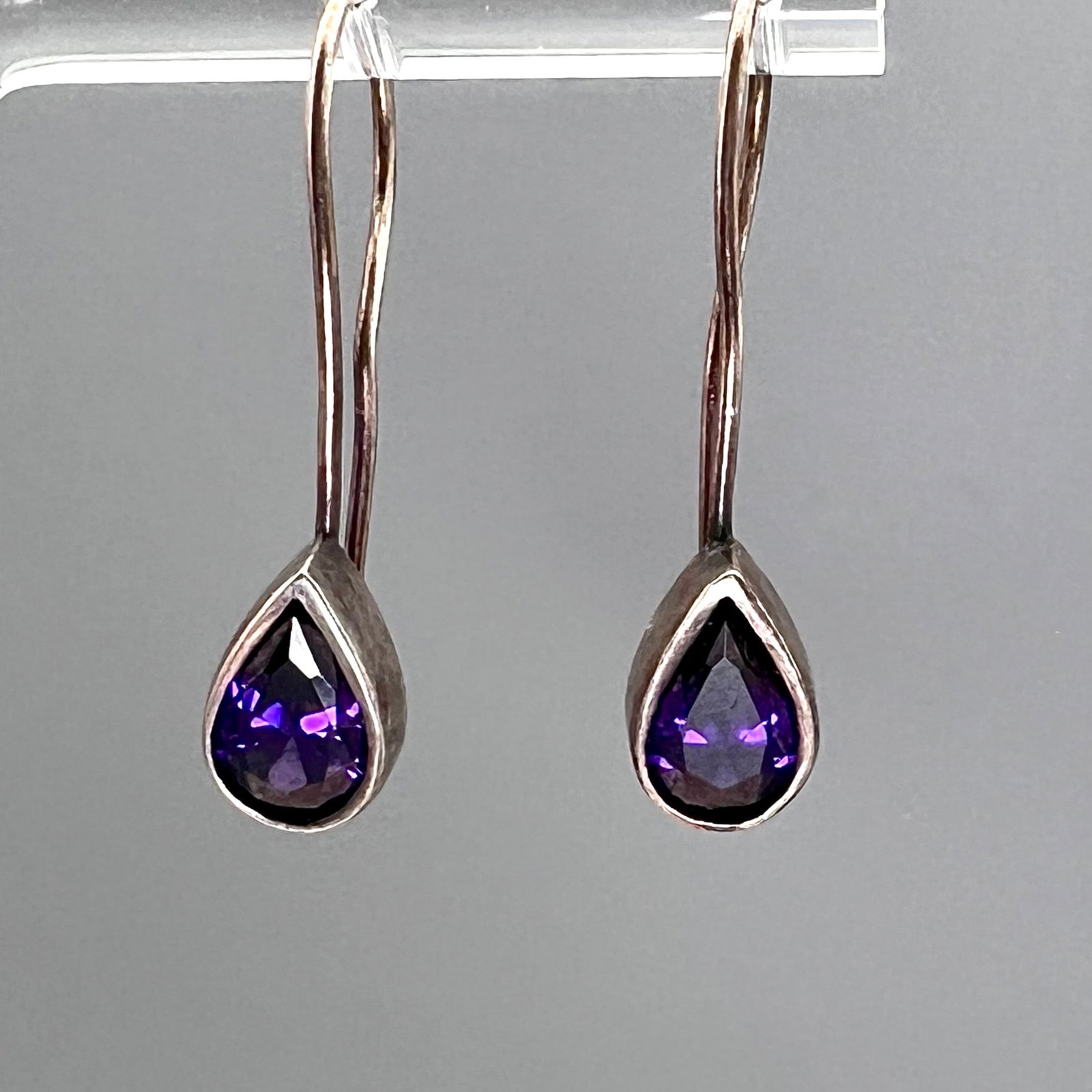 Vintage Sterling Silver Teardrop Amethyst Earrings with Marks: Elegant vintage drop earrings crafted in sterling silver, each featuring a faceted pear-cut amethyst in a secure bezel setting. The rich purple gemstones display excellent clarity and luster, with a d