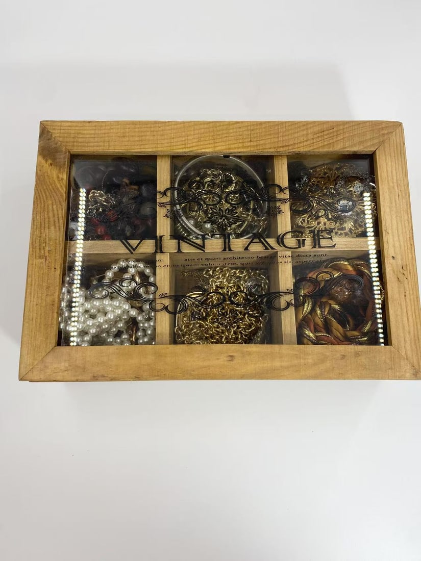 “Unsearched” Vintage Jewelry Wooden Box – Mystery Assortment: A charming wooden box with a glass lid labeled "Vintage," containing an unsearched assortment of jewelry and accessories. The compartments hold an intriguing mix of faux pearl strands, gold-tone chain