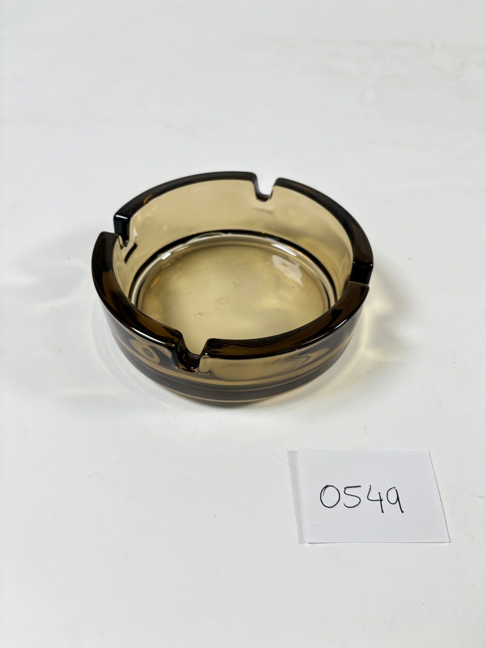 Vintage 1960s Smoked Glass Ashtray made in France: Elegant vintage smoked glass ashtray from the 1960s, made in France. Featuring a sleek and timeless design, this piece adds a sophisticated touch to any collection or decor. In good condition for its