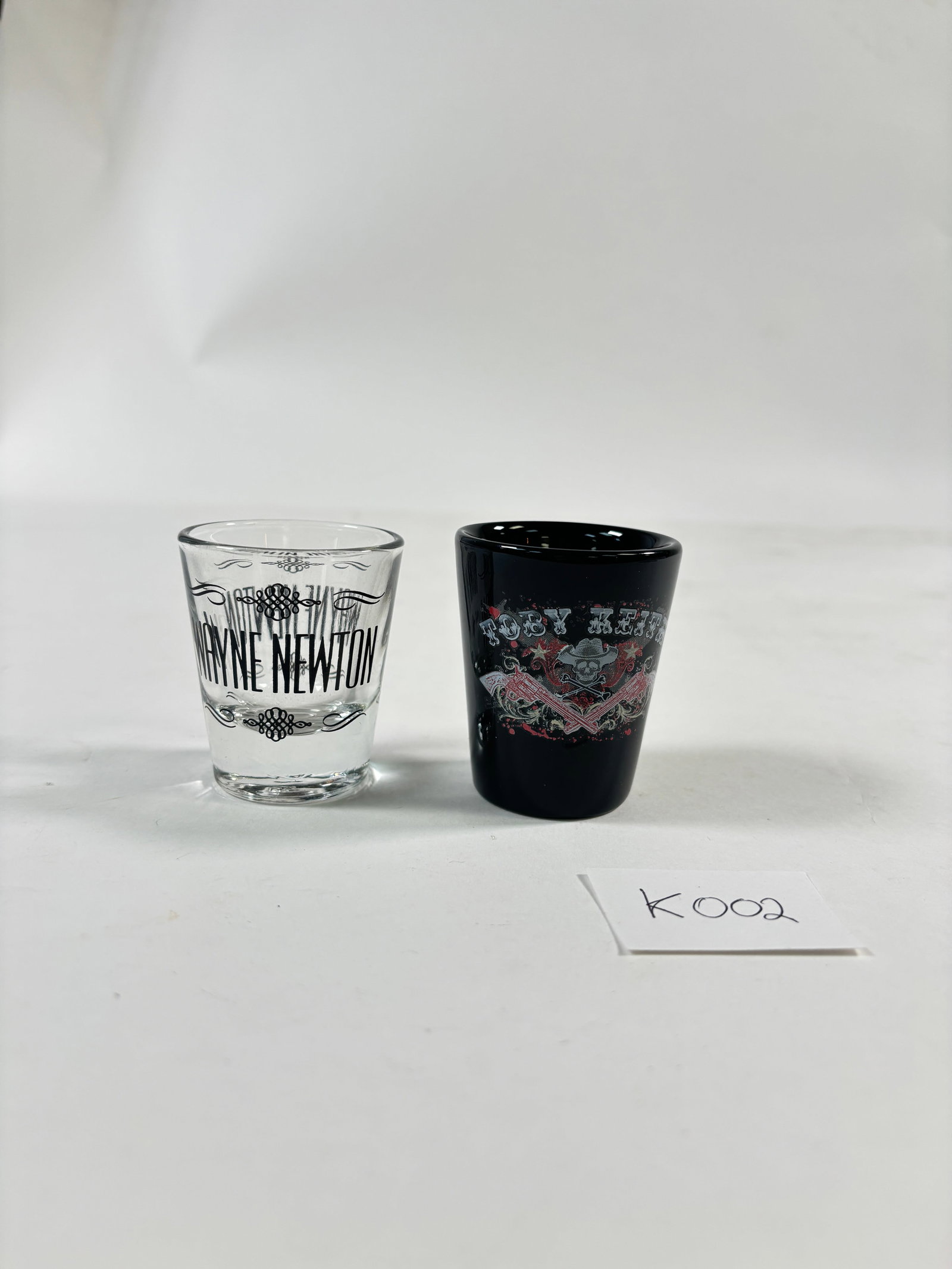 Vintage Shot Glasses Set of 2 (Toby Keith and Wayne Newton): Vintage Shot Glasses Set of 2 featuring Toby Keith and Wayne Newton. These collectible shot glasses are perfect for fans of these iconic performers. Each glass showcases unique designs related to the 