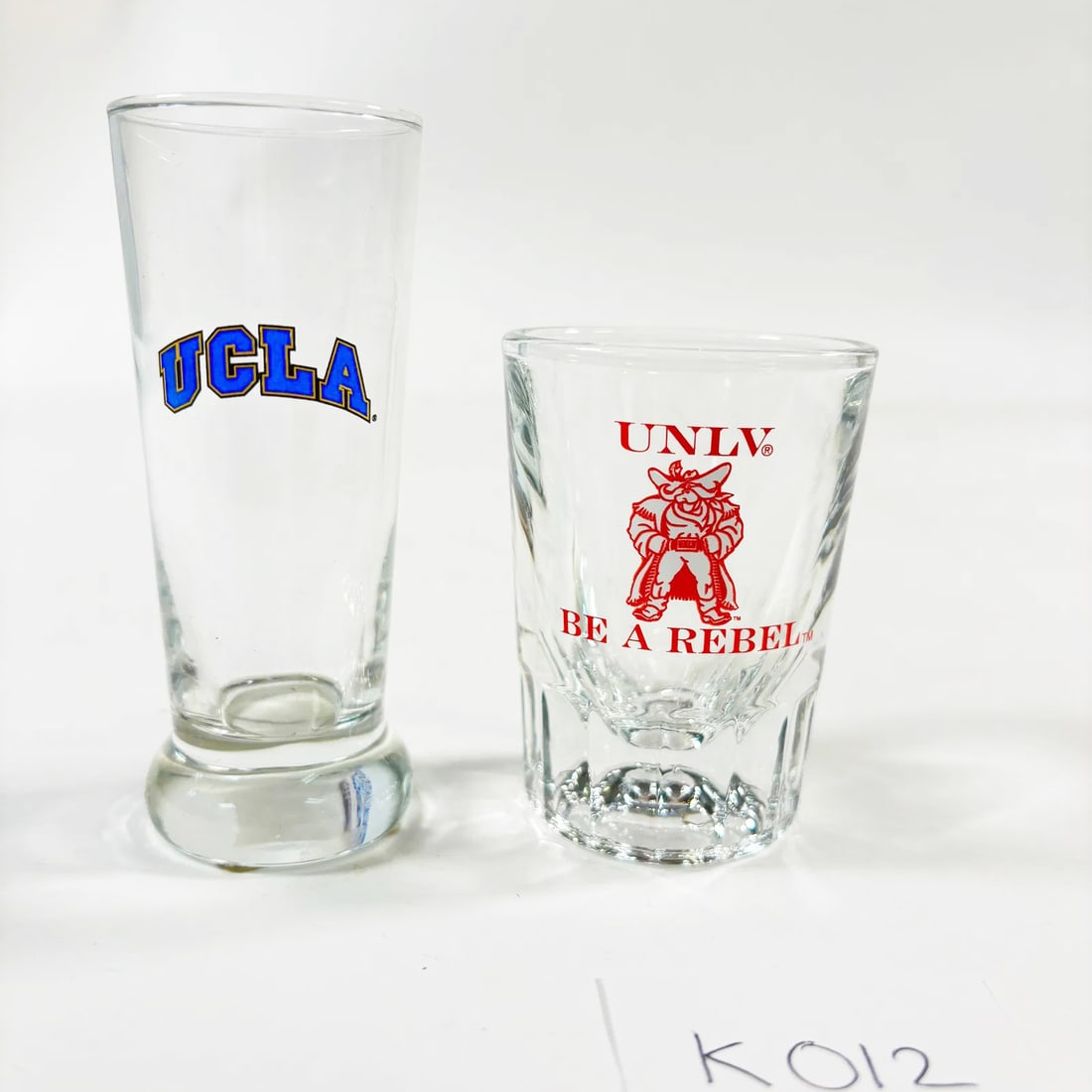 Vintage Shot Glasses Set of 2 (University Collectibles: UCLA and UNLV): Vintage Shot Glasses Set of 2, featuring collectible designs from the University of California, Los Angeles (UCLA) and the University of Nevada, Las Vegas (UNLV). Each glass showcases the respective u