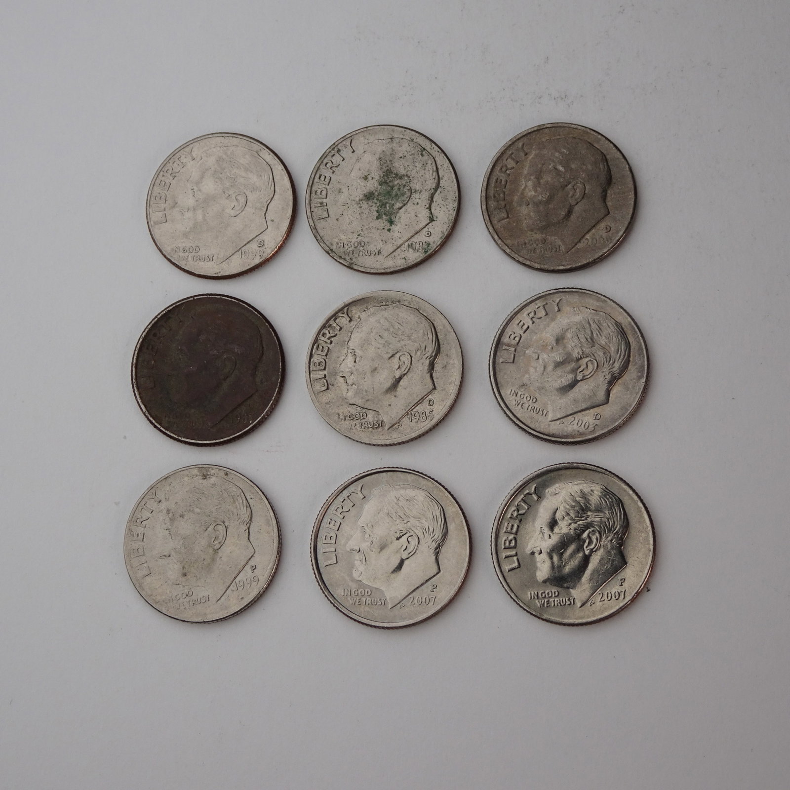 Assortment of USA Roosevelt Dimes Set of 9 (1982-2007): This listing is for an assortment of 9 USA Roosevelt Dimes, spanning various years from 1982 to 2007. Each coin features the portrait of Franklin D. Roosevelt on the obverse and an olive branch, torch