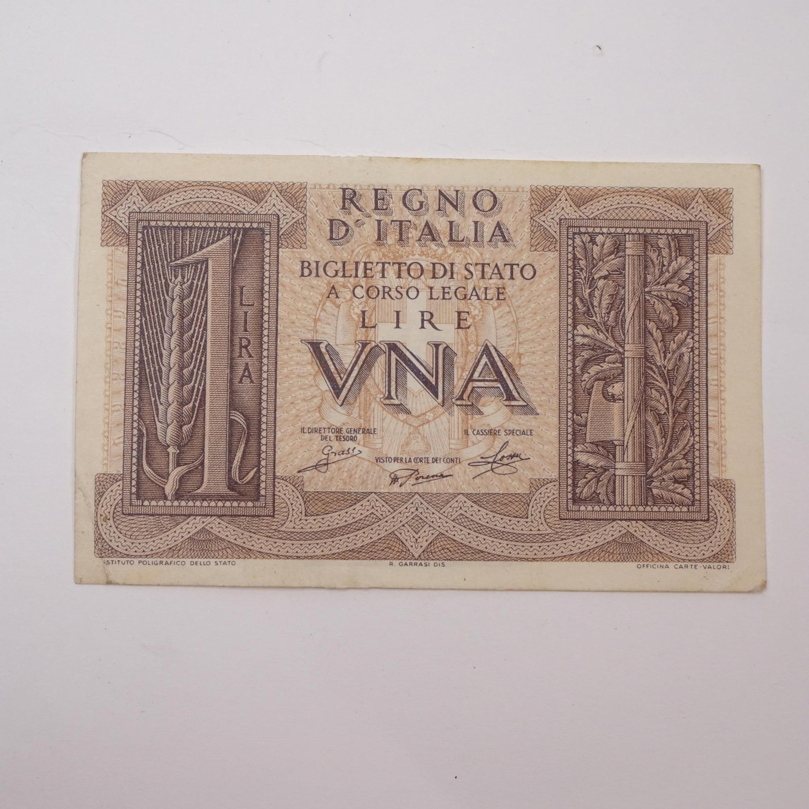 Italy - 1 Lire - 1939:: This WWII-era 1 Lire banknote from 1939 offers a glimpse into Italy's wartime currency issued just prior to and during the early years of the conflict. A historically significant piece for collectors 