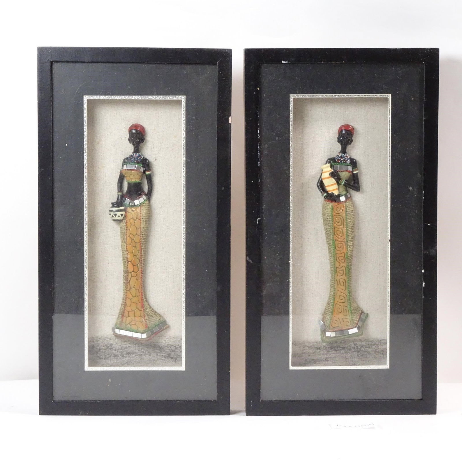 Shadowbox African Women Sculptures:: This "Shadowbox African Women Sculptures" display offers a captivating celebration of African artistry and culture. Featuring meticulously crafted sculptures of African women elegantly arranged within