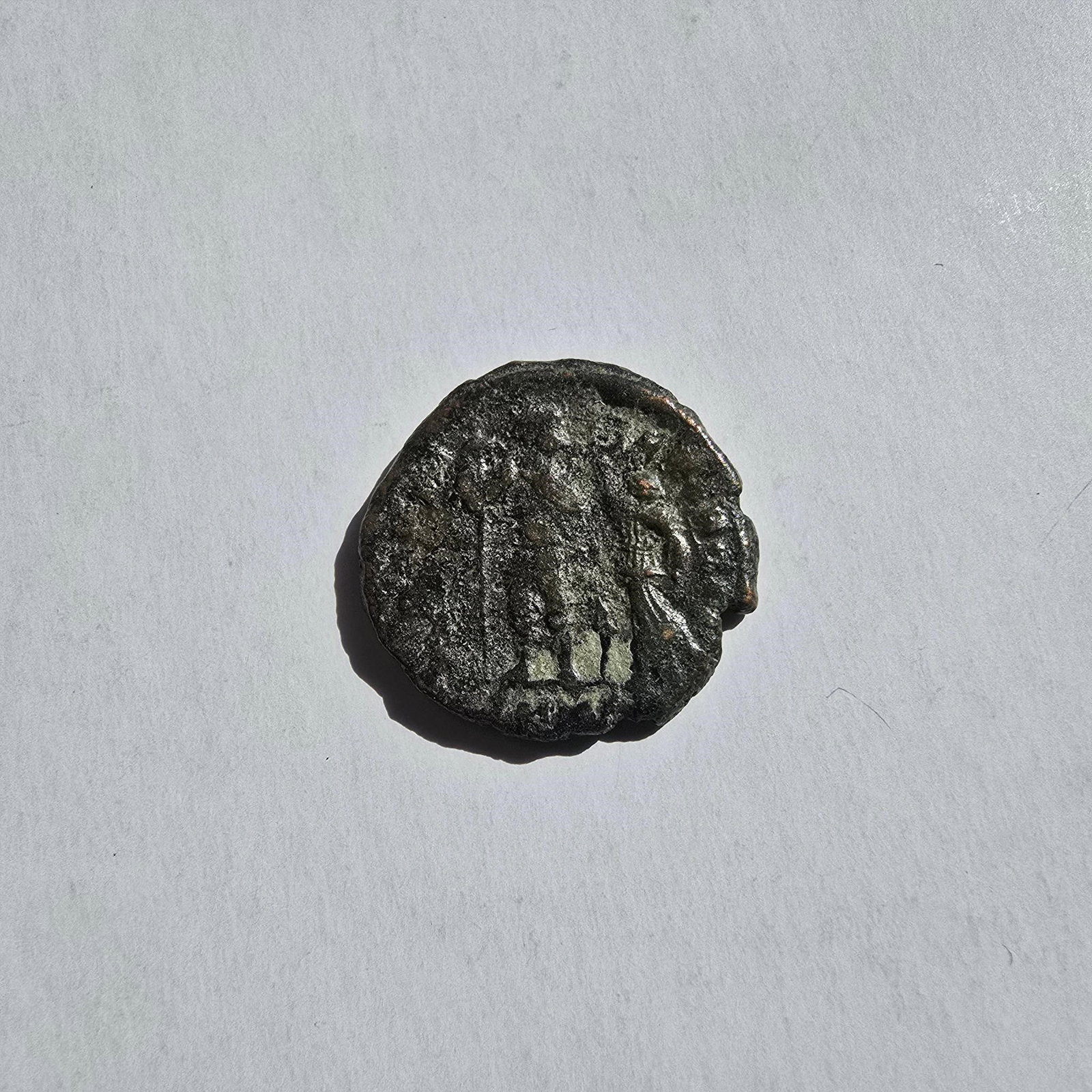 Ancient Roman Bronze Coin (c. 3rd-4th Century AD): Ancient Roman Bronze Coin (c. 3rd-4th Century AD)Offered here is an ancient Roman bronze coin, dating approximately to the 3rd-4th century AD. The obverse appears to depict a worn imperial bust, while