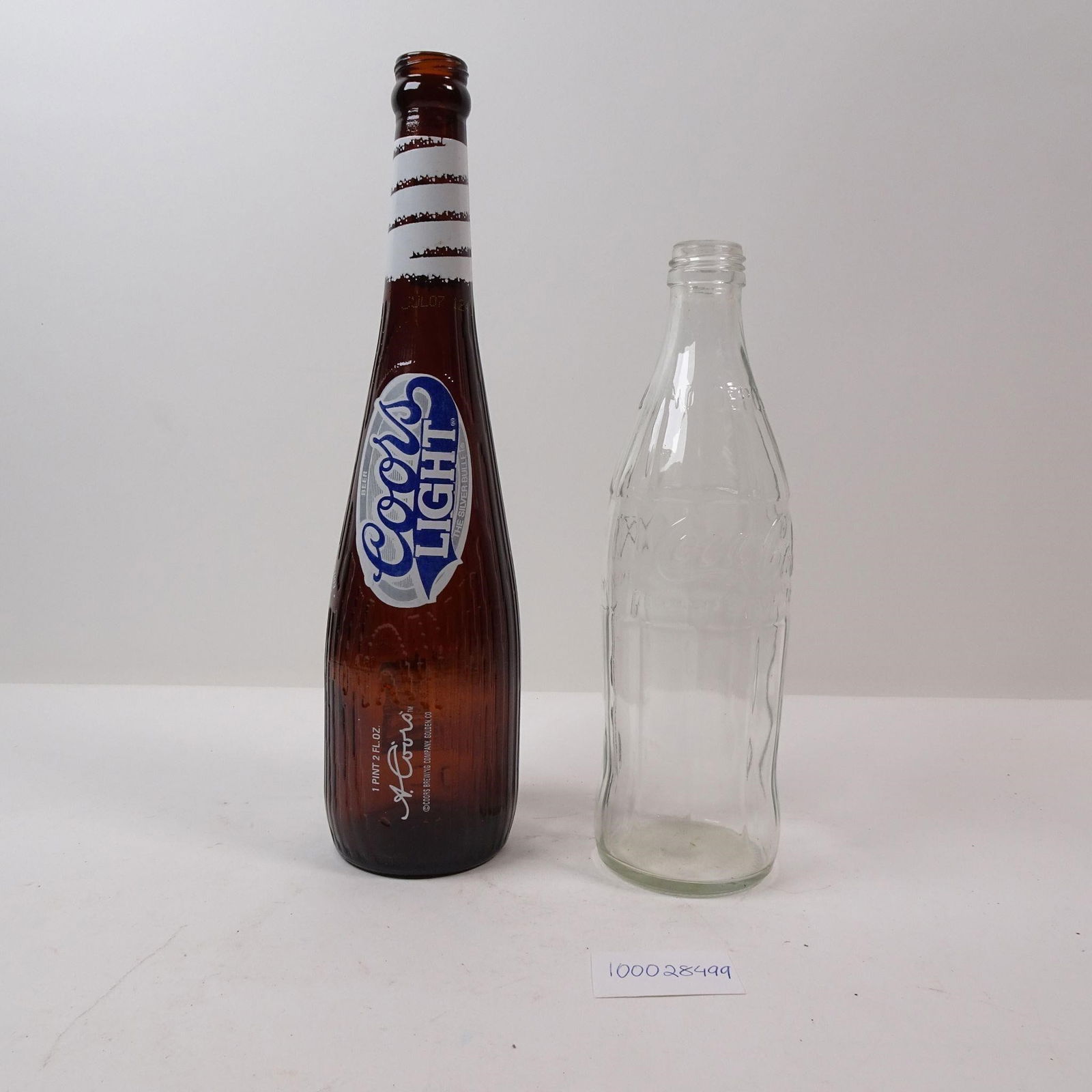 Vintage Coors Light Bottle and Coca Cola Bottle: A pair of vintage bottles featuring two iconic American brands: Coors Light and Coke. These collectible pieces are perfect for adding a touch of classic brand nostalgia and retro charm to any home bar