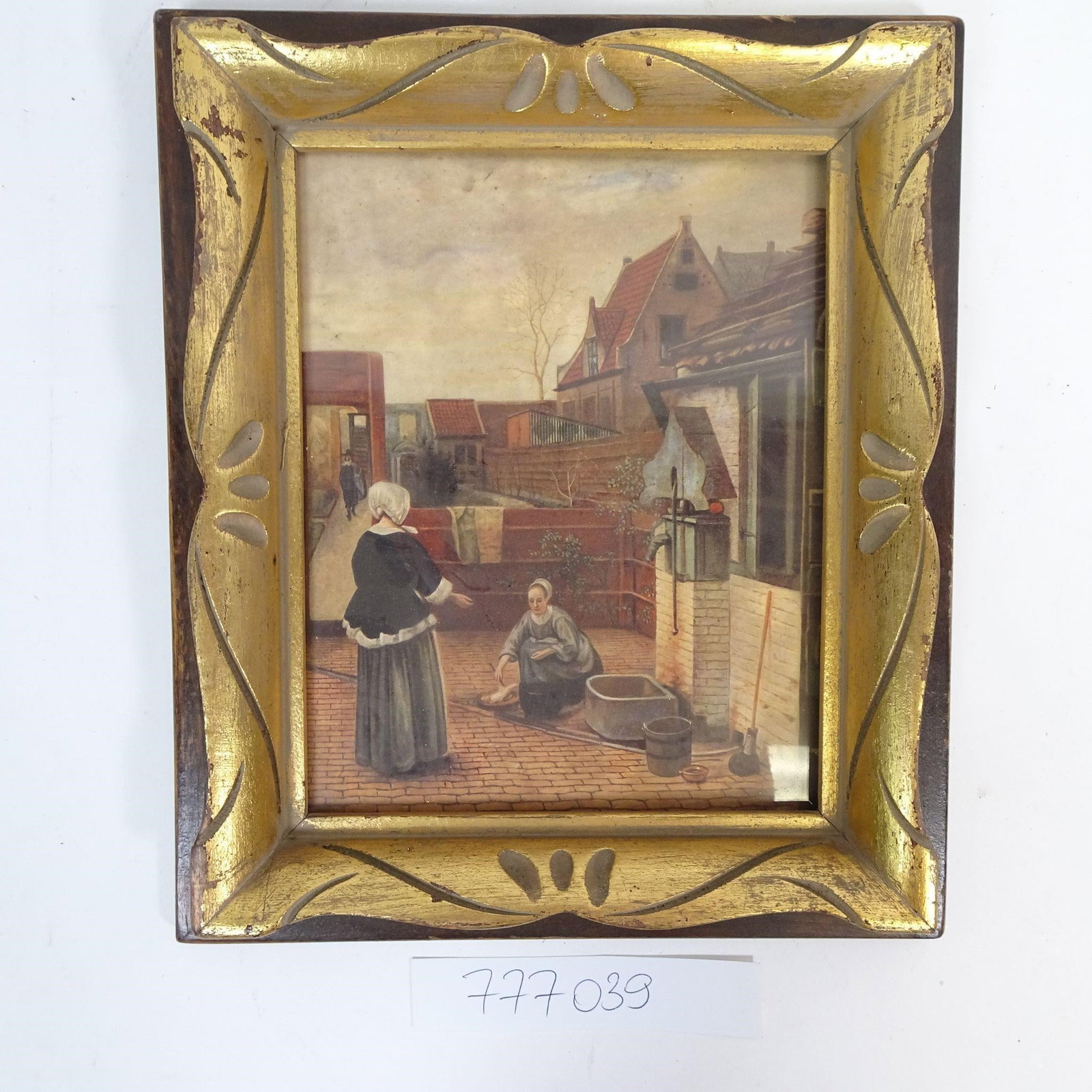 Framed European Courtyard Scene Print: Decorative vintage wall art featuring a European courtyard scene with figures engaged in daily life, set among traditional brick buildings and rooftops. The image captures a quiet, historic atmosphere