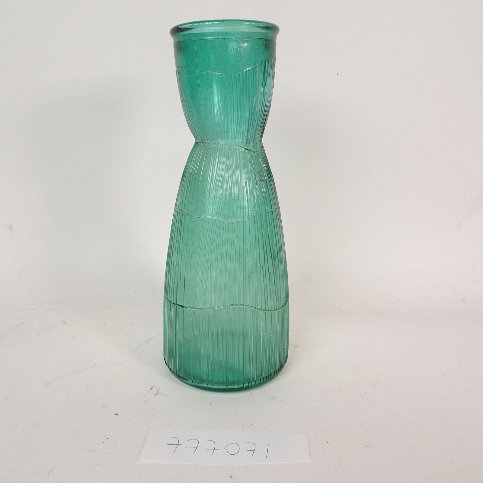 Vintage Green Glass Vase: Decorative vintage green art glass vase featuring a tall, elegant silhouette and ribbed textured surface. Made of thick glass in a rich green / turquoise tone, this piece has a beautiful handcrafted l