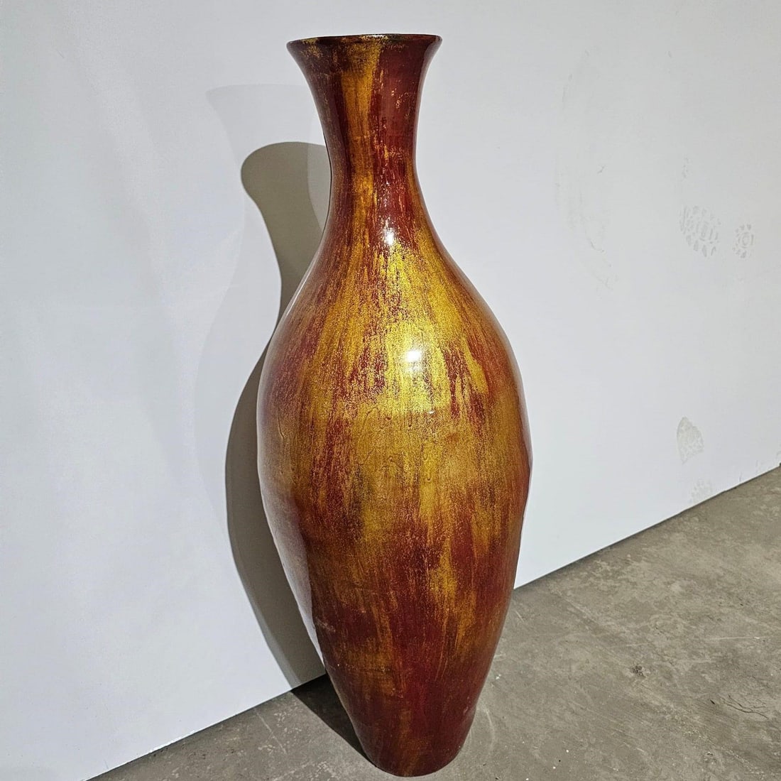 Large Decorative Floor Vase: Striking large decorative floor vase made of glazed ceramic. Features a tall, elegant silhouette and a hand-finished surface in warm tones of gold, copper, and deep red, giving it a rich and artistic