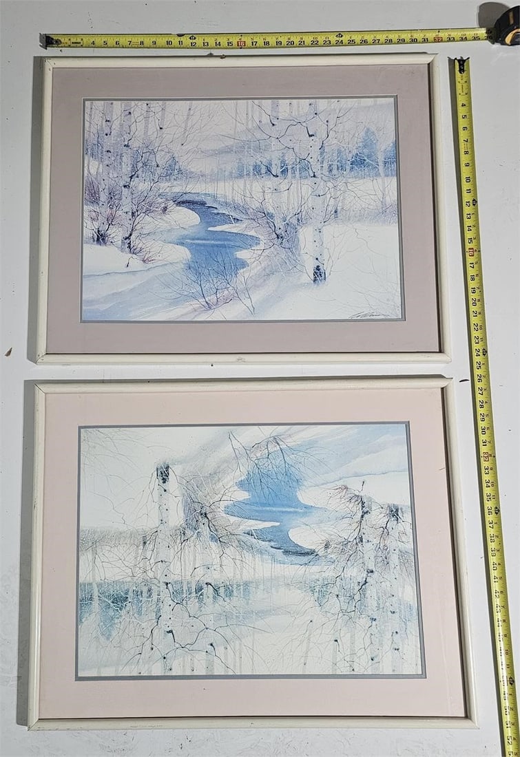 Set of 2 Framed Winter Landscape Prints: This auction features a set of two framed artworks depicting delicate winter landscapes in soft blue and white tones. Executed in watercolor / mixed media, these pieces have a calm, atmospheric, and