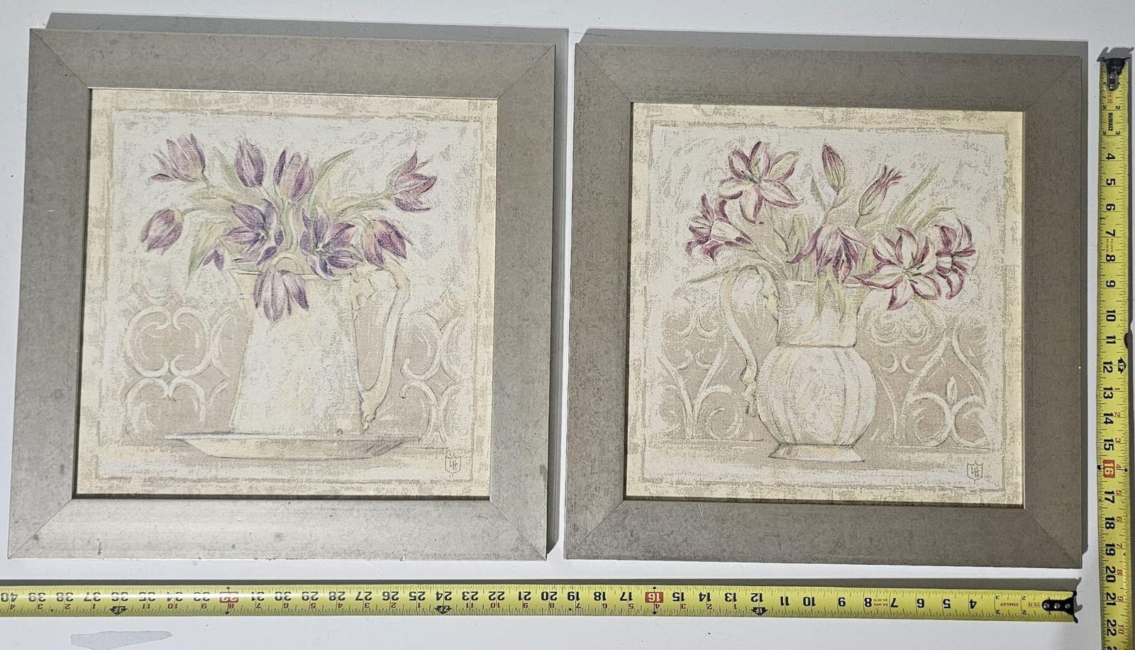 Set of 2 Framed Floral Prints: This auction features a set of two framed decorative floral prints depicting soft still-life compositions of flowers in vases. The artwork is rendered in gentle pastel tones with a calm, elegant