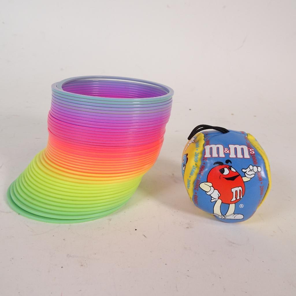 Vintage Toy & Novelty Lot: Unique mixed lot featuring a colorful plastic slinky toy, vintage Mickey Mouse ruler marked Walt Disney Productions, and a decorative compass-style novelty item. Items show age-related wear but remain