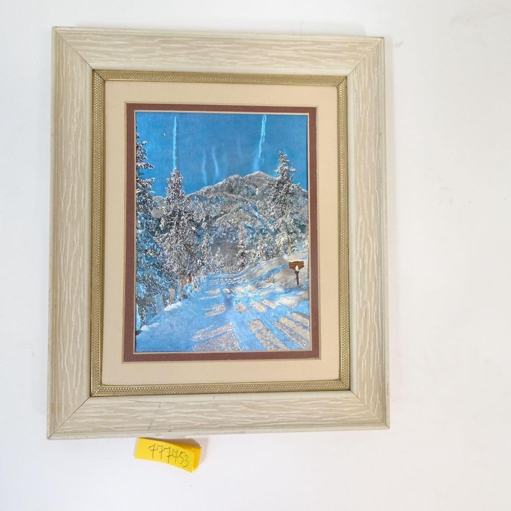 Framed Winter Landscape Artwork: Beautiful framed winter landscape artwork depicting a serene snowy path leading toward mountains and pine trees. The piece features cool blue tones with textured details, professionally matted and set