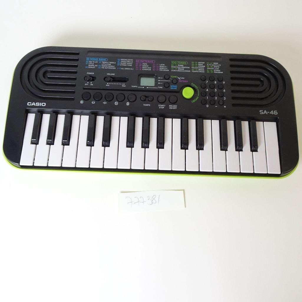 Casio SA-46 Electronic Keyboard: Compact Casio SA-46 electronic keyboard, designed for beginners and children. Features 32 mini keys, 100 built-in tones, 50 accompaniment rhythms, and 10 demo songs. Equipped with built-in speakers, v