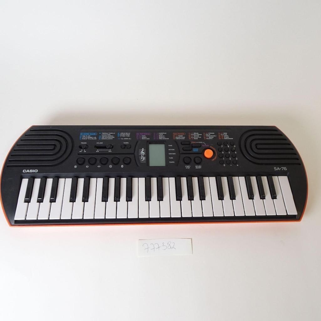 Casio SA-76 Electronic Keyboard: Compact Casio SA-76 electronic keyboard, designed for beginners and children. Features 44 mini keys, 100 built-in tones, 50 accompaniment rhythms, and 10 demo songs. Includes built-in speakers, LCD di