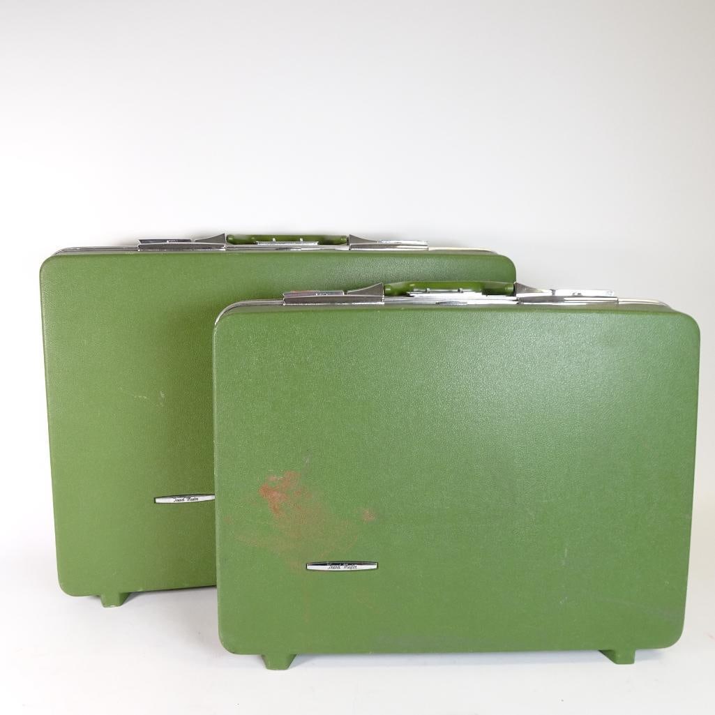 Vintage Green Mid Century Hard Shell Suitcases (2): Vintage hard shell luggage set featuring two matching green Travel Master suitcases. Classic mid-century design with chrome hardware, structured shape, and original interior lining with storage pocket