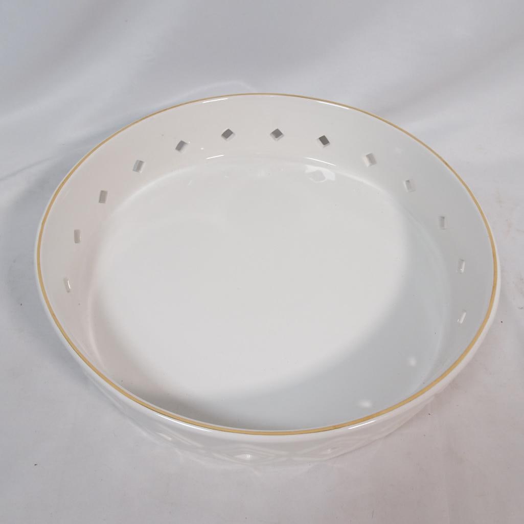 Large Stoneware Serving Bowl: Elegant Lilly Pulitzer for Target stoneware serving bowl featuring a clean white glazed finish with a delicate gold rim and a decorative geometric cut-out pattern around the sides. The raised diam