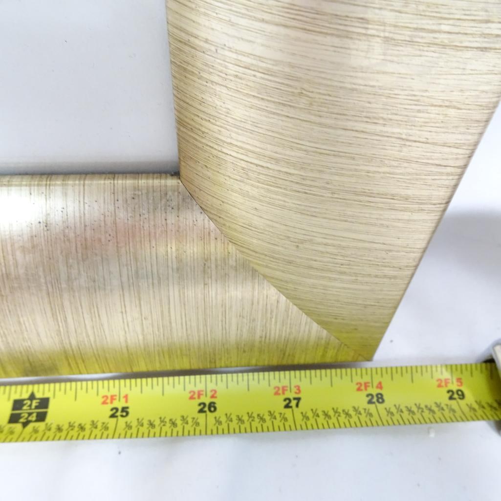 Framed Wall Art ?Icarus I: Elegant framed artwork titled ?Icarus I? by Made on Earth. This sophisticated composition features layered gold and silver feather forms set against a soft gray background. The piece is beautifully