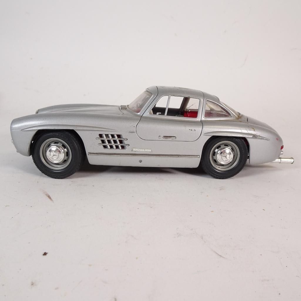 Vintage Mercedes-Benz 300 SL 1:18 Diecast Model Car: Authentic vintage Mercedes-Benz 300 SL diecast model car in 1:18 scale, produced by Bburago and made in Italy. Finished in classic silver with a red interior, this model features opening doors, detail