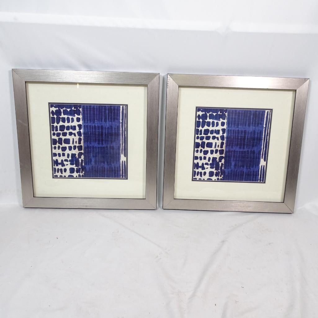 Set of 2 Blue Abstract Framed Art: Beautiful set of two matching framed art prints. Brand: Made on Earth Item: 3596 Approximate size (each): 22? x 22? Features: Bold blue abstract design Brushed silver contemporary frame Double matting