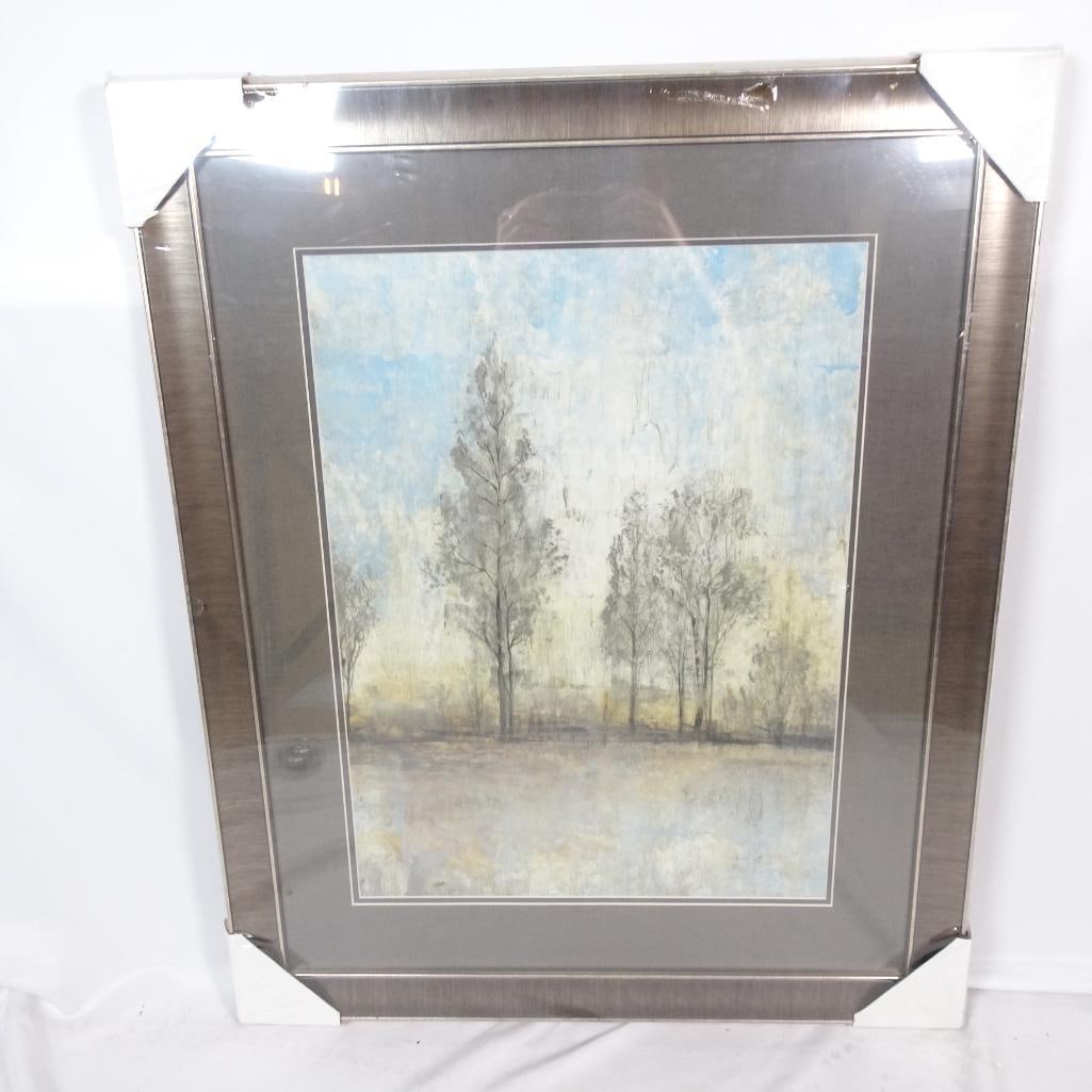 Large Framed Landscape Wall Art: Large framed landscape wall art featuring a soft, misty tree scene reflected over water in calming tones of blue, beige, cream, and gray. The artwork is professionally framed in a brushed
