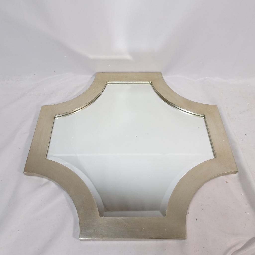 Modern Geometric Wall Mirror Champagne Silver Frame: Elegant modern decorative wall mirror featuring a unique geometric shape and a soft champagne-silver finished frame. The sculptural design makes it a beautiful accent piece for contemporary, modern, o