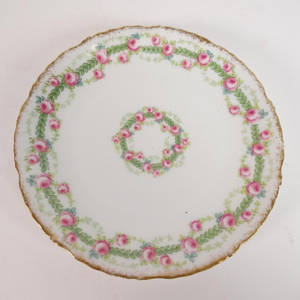 Elite Works Limoges France Porcelain Plate: Elegant vintage porcelain plate by Elite Works Limoges, France. Features a delicate pink rose garland design with soft green accents and gold gilt trim along the scalloped edge. Marked on the back: ?E
