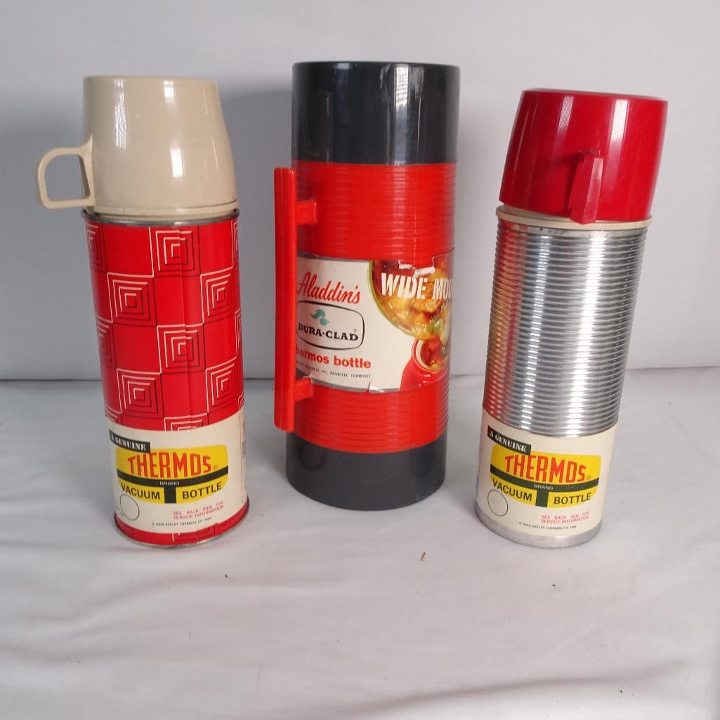 Vintage Thermos and Aladdin Bottles Lot of 3 - No Glass Inserts - For Parts or Display: Set of 3 vintage thermos bottles including Thermos brand and Aladdin. Please note: All bottles are missing the inner glass liners Sold as-is for parts, repair, or display/prop use Outer shells, cups, 