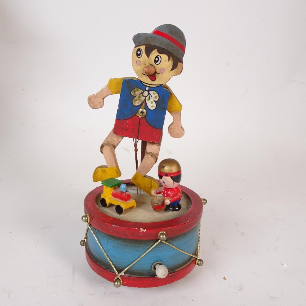 Enesco 1980 Pinocchio Animated Drummer Music Box Figure: Wonderful vintage wooden musical toy by Enesco (1980) featuring Pinocchio standing on a drum with moving legs when the crank is turned. Hand-painted wood, charming folk art style. Music plays when wou