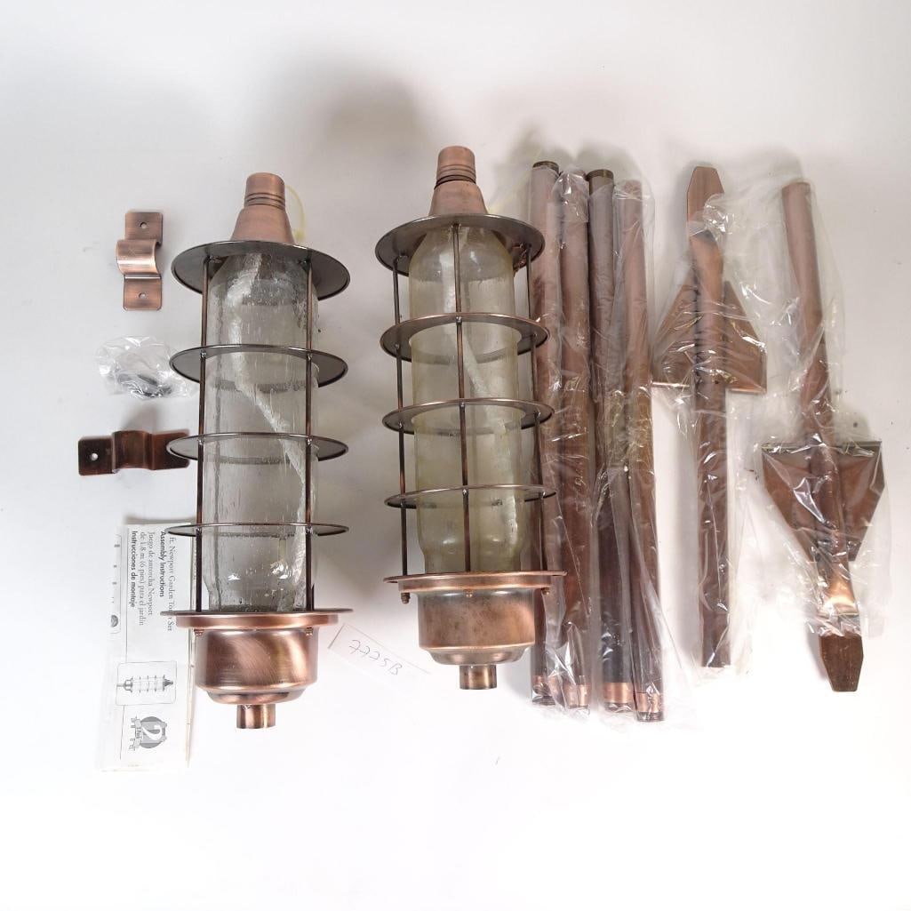 Copper Garden Torches Set with Poles and Parts: Single lot of outdoor copper garden torches. Includes two torch heads, poles, ground stakes, mounting brackets, screws, and instructions. Unassembled. Condition as shown. Sold as-is. All items in phot