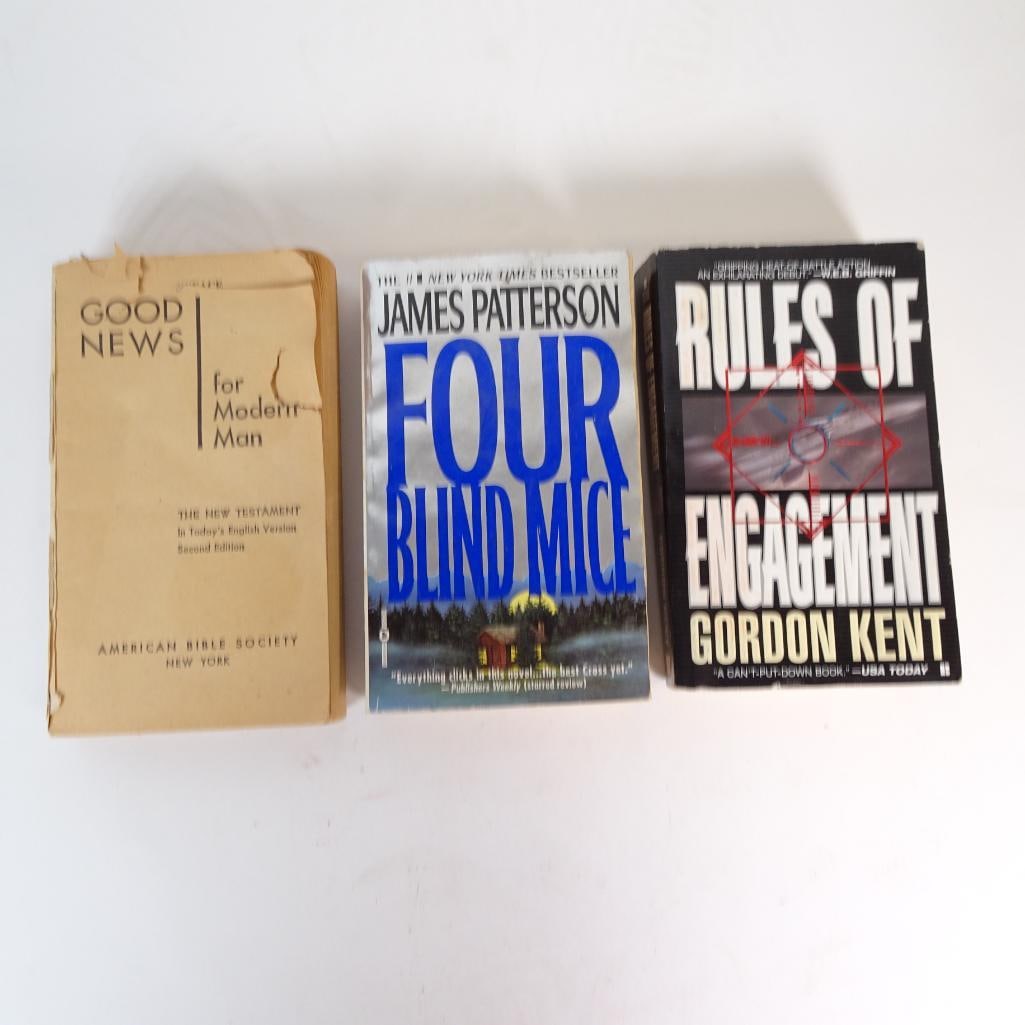 Mixed Book Lot of 3: Mixed paperback and vintage religious book lot including thriller fiction and a vintage New Testament edition. Condition: Pre-owned mixed condition. Visible edge wear, creasing, aging, sticker residue