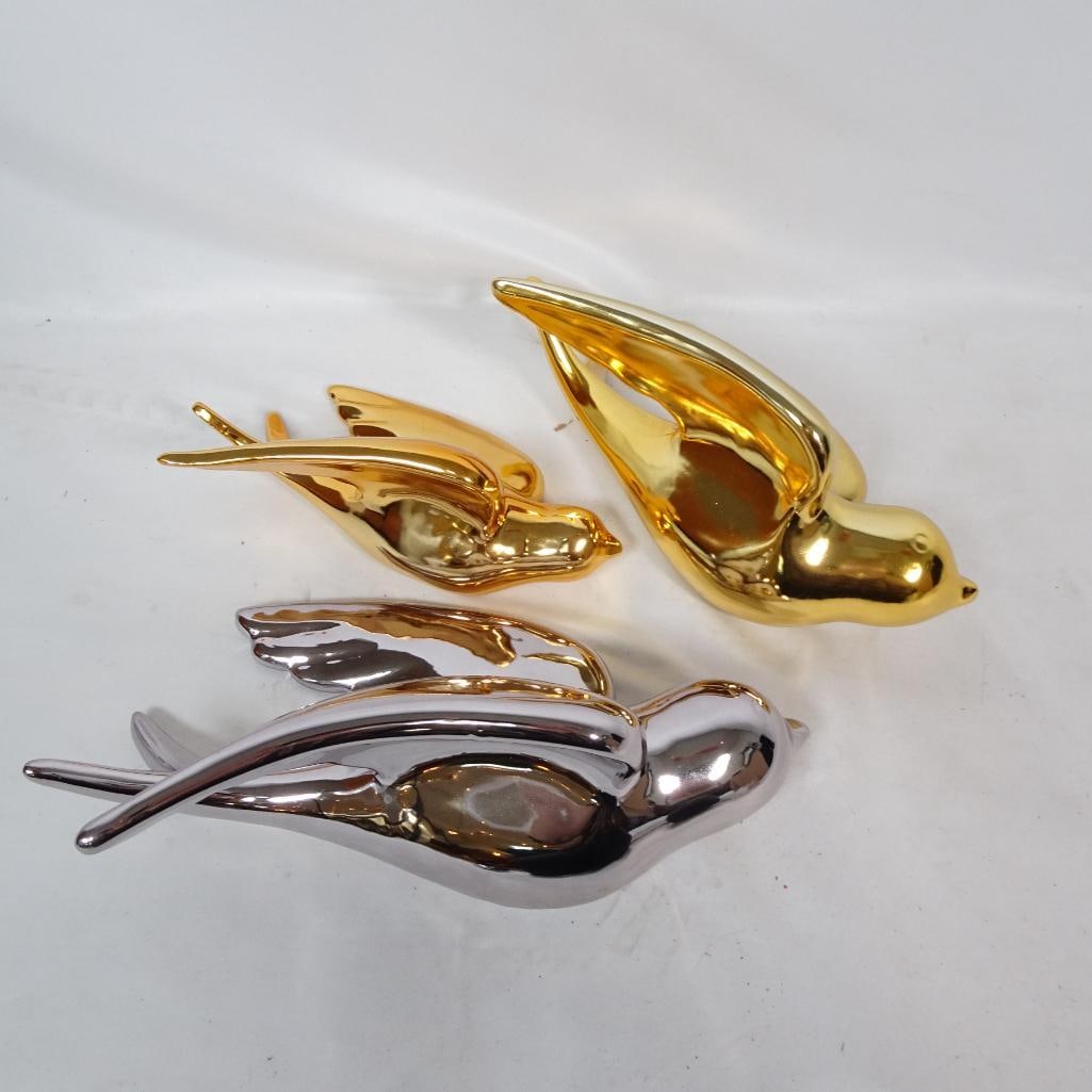 Gold and Silver Ceramic Birds: Beautiful set of 3 metallic flying swallow wall decor pieces. High gloss metallic finish. Ceramic construction. Wall hanging holes on back. Pre-owned condition. Minor surface wear consistent with disp