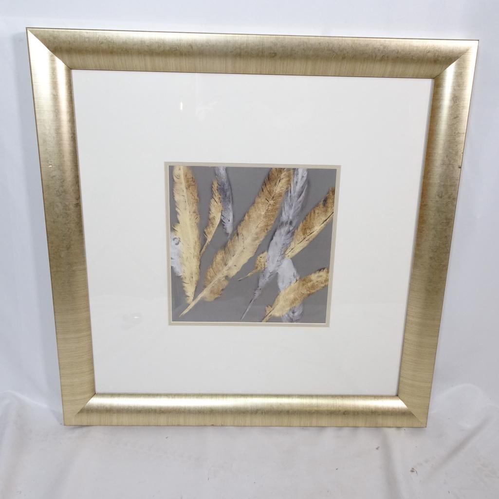 Framed Wall Art ?Icarus I": Elegant framed artwork titled "Icarus I" by Made on Earth. This sophisticated composition features layered gold and silver feather forms set against a soft gray background. The piece is beautifully ma