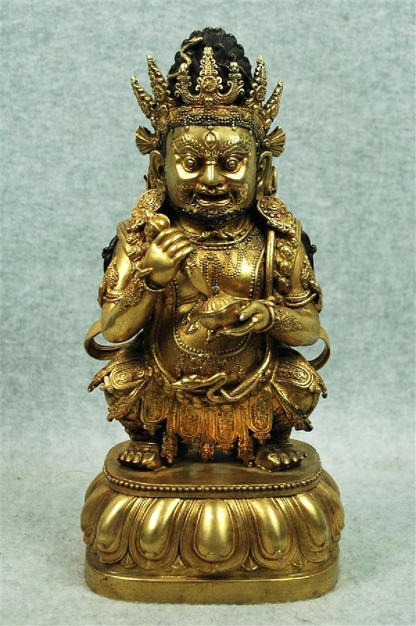 Sino-Tibetan Gilt Bronze Figure of a Dharmapala: Sino-Tibetan gilt bronze figure of a dharmapala, the Buddhist protector deity in princely raiment with the characteristic tantric ornaments, one hand with a vajra, the other holding a skull cup (kapal