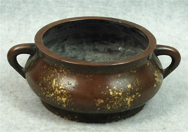 Chinese Gold-Splashed Bronze Censer: Chinese gold-splashed bronze censer, of compressed ovoid shape with a pair of loop handles below a slightly flaring thick rim, the sides scattered with gold-hued patches, the base cast with an apocryp