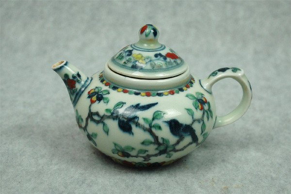 Chinese Dou-Cai Porcelain Teapot: Chinese doucai porcelain teapot, the globular body decorated in underglaze blue and colored enamels with birds perched on fruiting leafy branches, the short spout and opposing loop handle with floral 