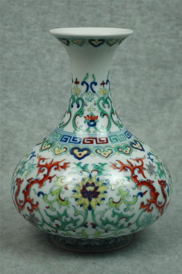 Chinese Dou-Cai Porcelain Vase: Chinese doucai porcelain ovoid vase, the globular body decorated in underglaze blue and colored enamels with stylized lotus blossoms and foliate-body dragons amid leafy scrollwork and bracketed by ruy