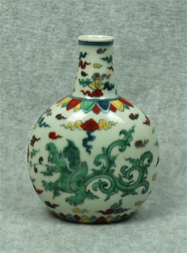 Chinese Dou-Cai Porcelain Vase: Chinese doucai porcelain ovoid vase, the slightly flattened globular body decorated in underglaze blue and bright enamels with dragons amid cloud scrolls repeated on the tapering neck with a band of o