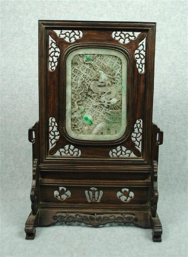 Chinese Hardwood Table Screen With Jadeite Panel: Chinese hardwood table screen with jadeite panel, the pale green stone plaque carved and undercut with a dragon and crane above a country villa, reversed by a large phoenix in flight, each with portio