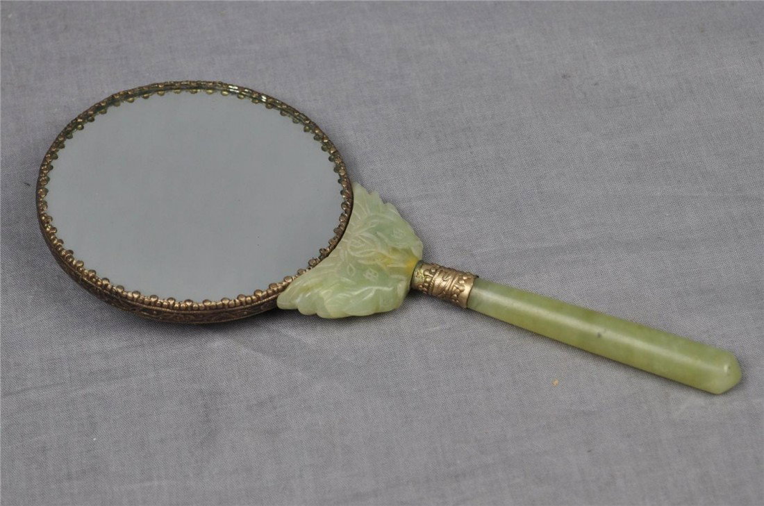 Chinese Decorative Round Shape Hand Mirror: Chinese decorative round shape hand mirror, decorated with jade stone as handle and Chinese characters on silver lead back cover. 8.25" height.