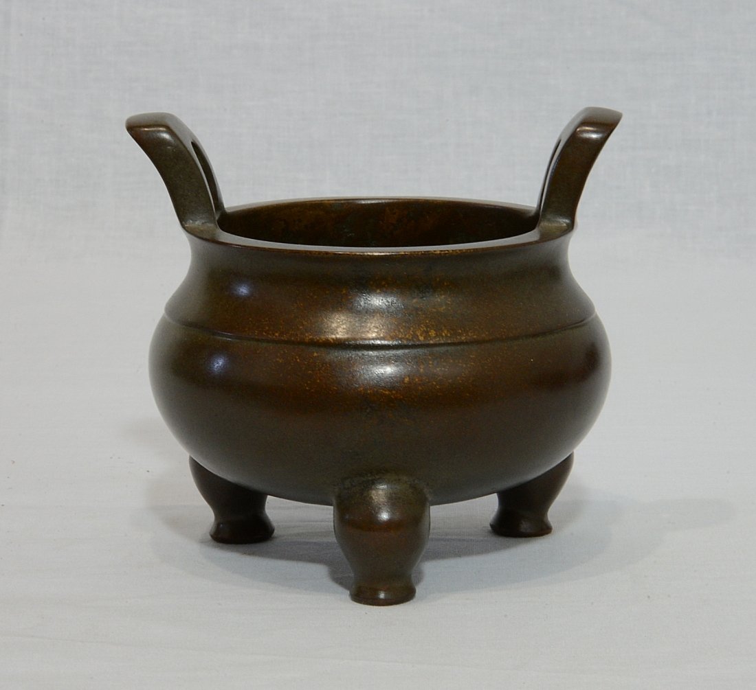 Chinese Bronze Tripod Incense Burner With Mark: Chinese bronze tripod incense burner with handles. Four character relief mark on the base. Good condition. 5" diam x 3.5" height.